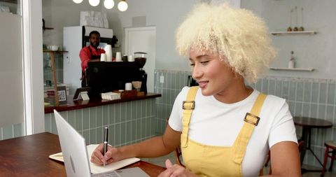 Young woman working on laptop in relaxed cafe atmosphere
