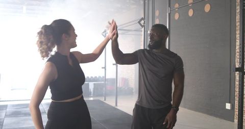 Diverse Young Athletes Celebrating Success in Industrial Gym