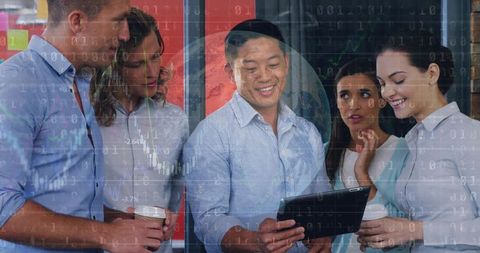 Smiling man holding tablet sharing data with colleagues in modern office for teamwork