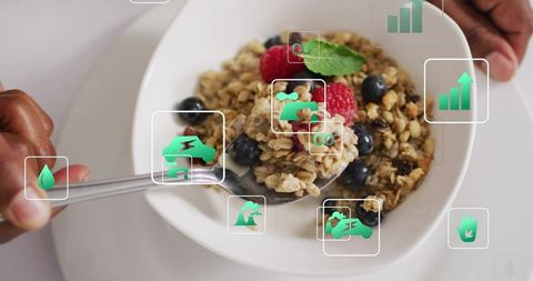 Scooping granola with berries and mint, man holding spoon and steadying bowl, eco icons overlay