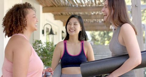 Diverse Women Chatting Outdoors with Yoga Mats Celebrating Fitness
