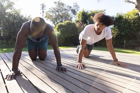 Diverse Male Friends Training Outdoors Together on Wooden Deck