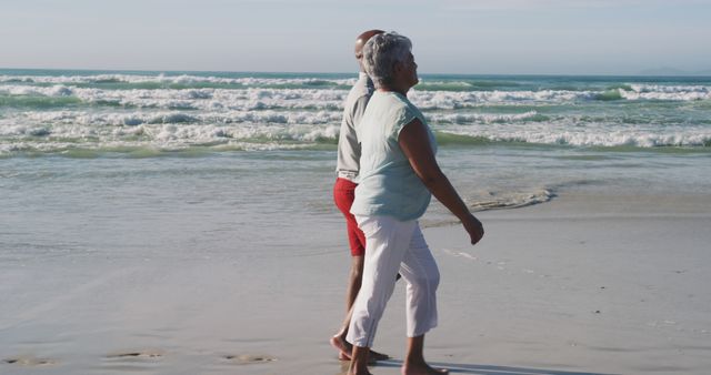 Senior african american couple walking and holding hands at the beach. healthy outdoor leisure time by the sea.
