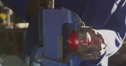 Technician Securing Baseball in Vise for Mechanical Inspection