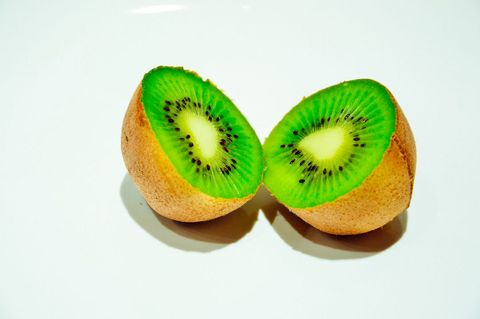 Freshly cut kiwi against white background
