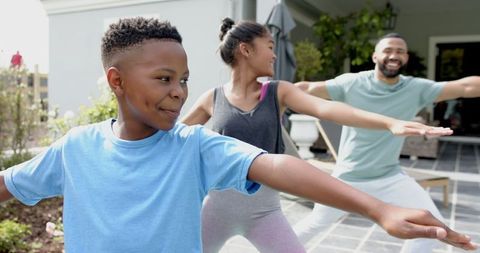 Happy Family Practicing Yoga in Outdoor Garden Setting