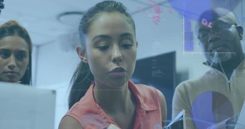 Diverse Team Collaborating on Technology Project Under Office Lighting