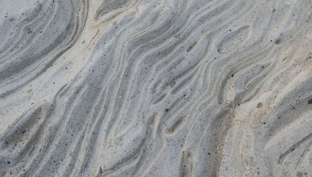 Coastal bedrock revealing rippled laminae and pebble-speckled sedimentary texture