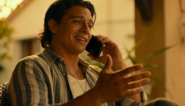 Sunlit casual man speaking on smartphone, gesturing on porch during golden hour, relaxed