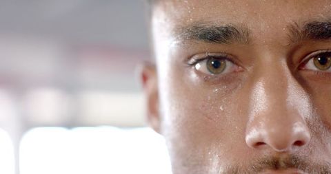 Determined young man with focused eyes sweating post-workout