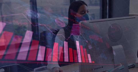 Businesswoman analyzing financial data on computer with covid-19 safety measures