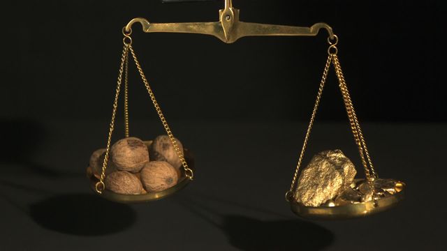 Rustic balance scales delicately fluctuating as gold and nuts sway delicately from each side symbolize an intriguing comparison of value and wealth in historical or trading concepts. This image could be ideal for illustrating points in presentations or articles focusing on economics, comparative valuation of distinct commodities, or cultural perspectives concerning wealth and natural resources.