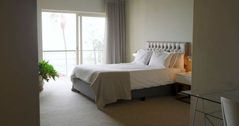 Modern King-Size Bedroom with Balcony and Palm Views