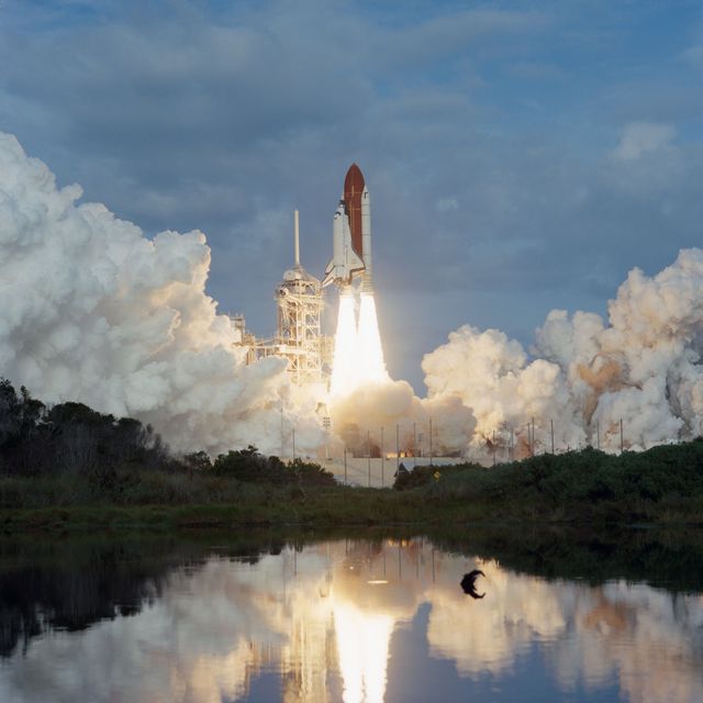 Space Shuttle Endeavour launching into orbit with billowing smoke and reflection in water. This iconic image captures the moment of liftoff taken on January 13, 1993. Suitable for educational materials about space exploration, promotions for science museums, or illustrating technological achievements in aerospace.