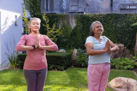 Senior Women Practicing Yoga in Serene Backyard
