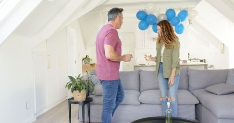 Mature Couple Celebrating at Home with Decorative Balloons