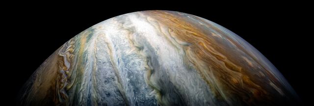 Colorful swirling cloud belts dominate Jupiter's southern hemisphere in this image captured by NASA's Juno spacecraft.  Jupiter appears in this color-enhanced image as a tapestry of vibrant cloud bands and storms. The dark region in the far left is called the South Temperate Belt. Intersecting the belt is a ghost-like feature of slithering white clouds. This is the largest feature in Jupiter's low latitudes that's a cyclone (rotating with clockwise motion).  This image was taken on Dec. 16, 2017 at 10:12 PST (1:12 p.m. EST), as Juno performed its tenth close flyby of Jupiter. At the time the image was taken, the spacecraft was about 8,453 miles (13,604 kilometers) from the tops of the clouds of the planet at a latitude of 27.9 degrees south.  The spatial scale in this image is 5.6 miles/pixel (9.1 kilometers/pixel).  Citizen scientist Kevin M. Gill processed this image using data from the JunoCam imager.  https://photojournal.jpl.nasa.gov/catalog/PIA21974