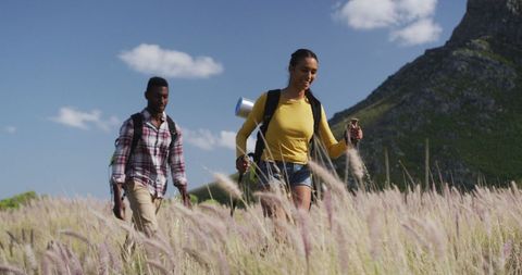 Couple Hiking Through Scenic Mountain Grassland