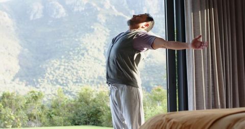Asian Man Embracing Nature with Morning Stretch in Tranquil Scenic Bedroom