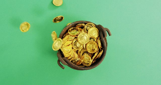 This image of a pot filled with gold coins overflowing onto a green background conveys themes of wealth, fortune, financial success, and abundance. It is ideal for illustrating concepts related to investment, savings, business prosperity, and money-related opportunities in blogs, financial websites, and marketing materials.