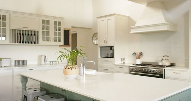 Kitchen island, sink, oven, gas stove and white furnitures in sunny kitchen. Interior design, dome and domestic life.