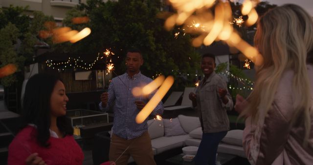 Joyful Friends Celebrating with Sparklers on Rooftop - Download Free Stock Images Pikwizard.com