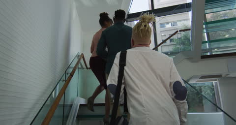 Diverse Team Walking Up Staircase in Modern Office Environment
