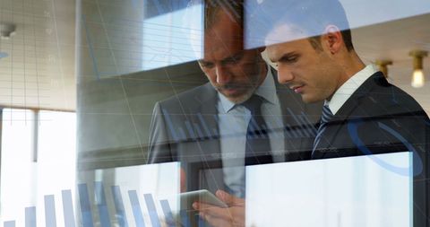 Business Professionals Analyzing Financial Data Using Tablet