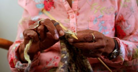 Senior woman knitting yarn in nursing home comfort