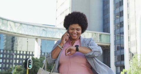Joyful Professional with Smartwatch Walking in Urban Environment