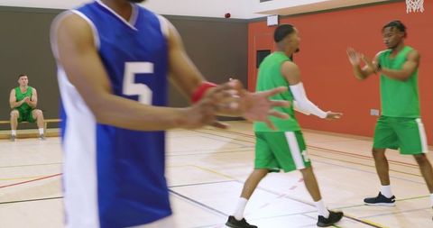 African american basketball players competing on indoor court, passing and defending, teamwork