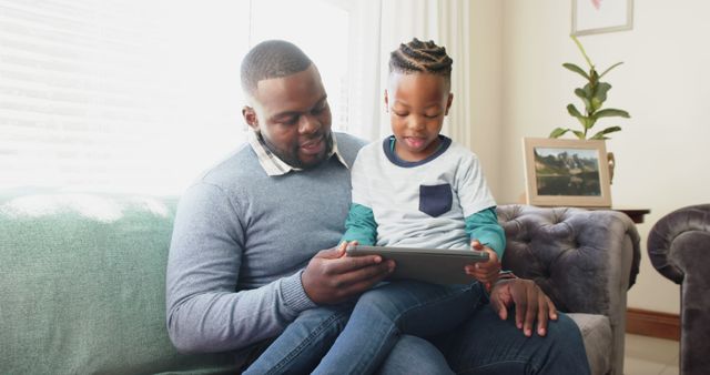 Father and Son Spending Quality Time with Digital Tablet on Sofa - Download Free Stock Images Pikwizard.com