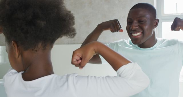 Father and Daughter Flexing Muscles and Smiling in Bathroom - Download Free Stock Images Pikwizard.com