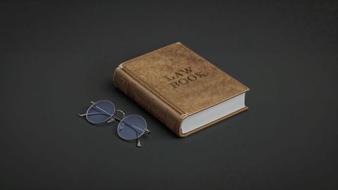 Vintage law book and glasses on minimalist gray background