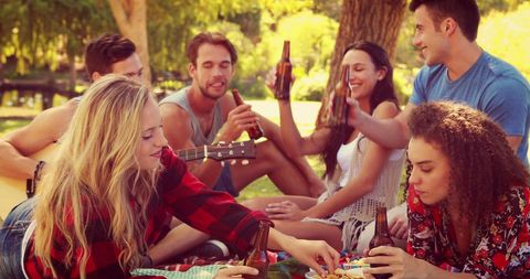 Diverse Friendship Group Enjoying Relaxing Picnic in Park