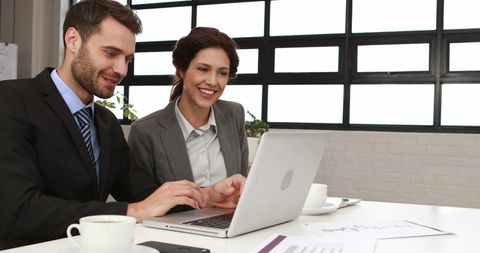 Business Professionals Collaborating on Laptop in Office