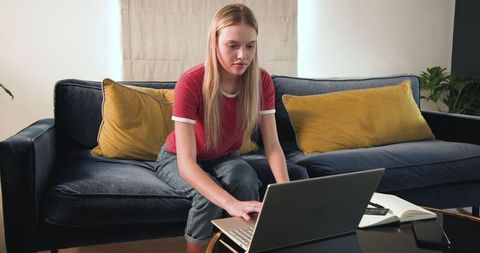 Teenager Shopping Online with Laptop and Credit Card at Home