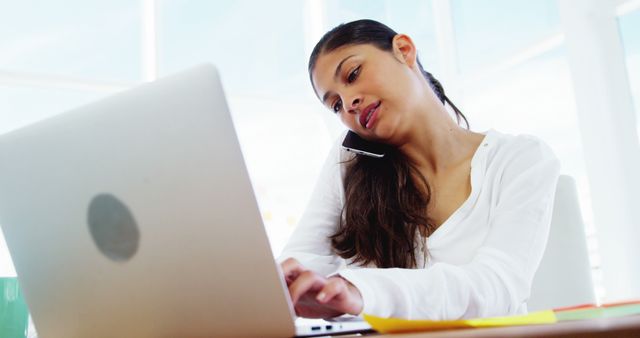 Young Professional Woman Multitasking on Laptop and Phone - Download Free Stock Images Pikwizard.com