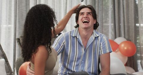 Joyful couple celebrating birthday at home gathering
