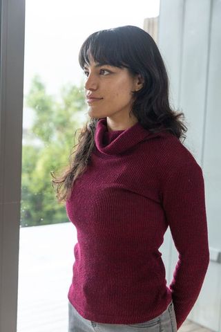 Woman Gazing Out Glass Window in Modern Urban Setting