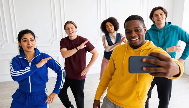 Diverse group taking selfie during energetic dance rehearsal in bright studio