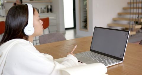 Young Woman Using Laptop and Smartphone at Home Office