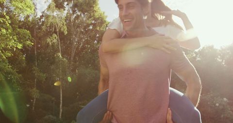 Joyful Couple Enjoying Piggyback Ride in Sunny Garden - Download Free Stock Images Pikwizard.com