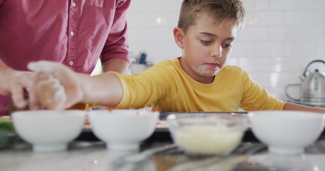 Young boy baking with parent in home kitchen, reaching for ingredients - Download Free Stock Images Pikwizard.com