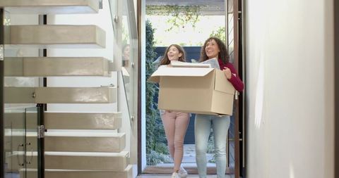 Mother and Daughter Arriving Home with Moving Box