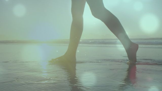 Video shows woman walking barefoot on beach in ethereal light with a serene ocean in background. Great for concepts of relaxation, tranquility, beach activities, wellness, relaxation, holiday advertisements, serene retreats, and lifestyle blogs.