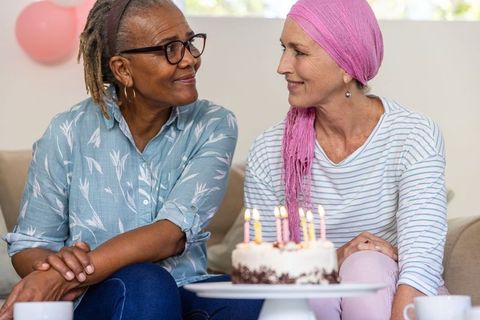 Diverse Female Friends Celebrating Birthday with Cake on Sofa