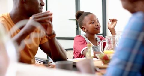 African American Family Enjoying Meal Together at Dining Table