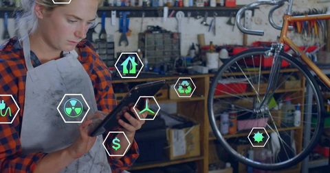 Woman bike technician scanning bicycle with tablet using augmented reality diagnostics