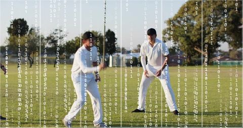 Club cricket fielders reacting to ball on sunlit grass with binary code overlay